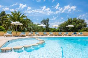ein Swimmingpool mit Liegestühlen und Sonnenschirmen in der Unterkunft Luxusfinca Son Mas in Felanitx