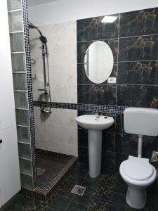 a bathroom with a sink and a toilet and a mirror at Apartament CAMEL in Eforie Nord
