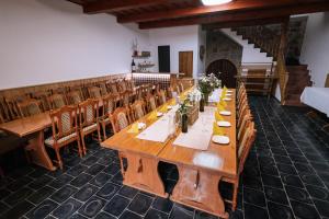 a long wooden table in a room with chairs at Vinný sklep André in Chvalovice