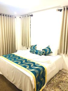 um quarto com uma cama e uma janela grande em Venus Inn Nuwara Eliya em Nuwara Eliya