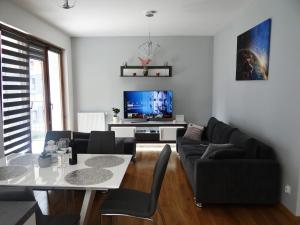 クラクフにあるBeautiful City Centre Apartamentのリビングルーム(ソファ、テーブル、テレビ付)