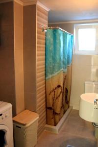 un bagno con tenda da doccia e lavandino di Chania City Home a Chania