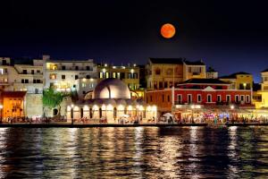 una vista di una città di notte con luna piena di Chania City Home a Chania