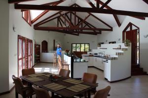 une femme debout dans une cuisine avec une table dans une pièce dans l'établissement Bularangi Villa, Fiji, à Rakiraki