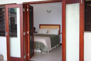 ein Schlafzimmer mit einem Bett und einer Glastür in der Unterkunft Bularangi Villa, Fiji in Rakiraki