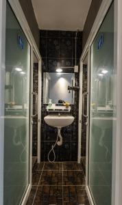 y baño con lavabo y ducha acristalada. en The Z Nite Hostel, en Phuket