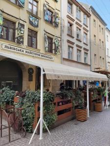 a store with awning in front of a building at Apartment in Serbska Lviv in Lviv