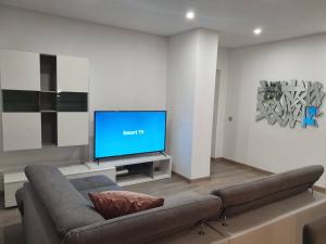 a living room with a couch and a flat screen tv at PÉROLA D'ÓBIDOS t2 in Óbidos