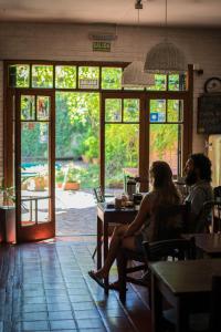zwei Personen sitzen an einem Tisch in einem Restaurant in der Unterkunft Hostel Posada Juan Ignacio in Rosario