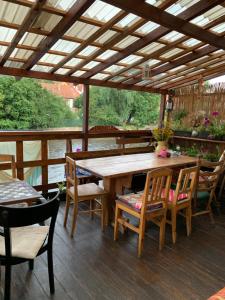 una mesa de madera y sillas en una terraza de madera en Hostelskippy en Český Krumlov