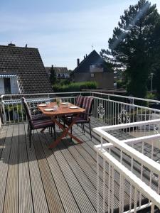 una terraza de madera con mesa y sillas. en Ferienwohnungen Grömitz Seeweg, en Grömitz