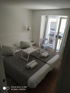 a large bed with two pillows on it in a room at Apartamento El Reloj in San Sebastián