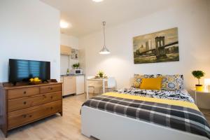 Un dormitorio con una cama y un televisor de pantalla plana. en Apartamenty Zamulkowa 4TWO, en Katowice