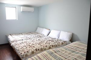 1 dormitorio con 2 camas y ventana en Yokocho Building / Vacation STAY 42628, en Beppu