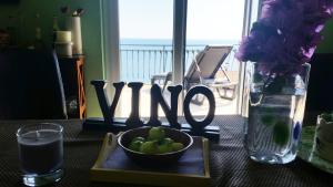 a table with a bowl of fruit and a sign that reads vine at Apartments Vila Vino in Sveta Nedelja