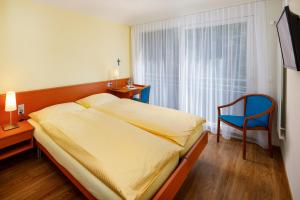 Postel nebo postele na pokoji v ubytování Hotel Klausenhof Flüeli
