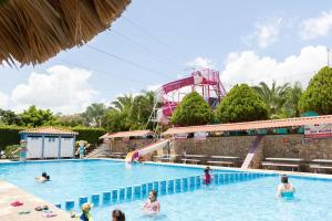 a group of people in a swimming pool with a roller coaster at Camino Mexicano Hotel & Resort in Tuxtla Gutiérrez