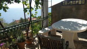 a table and chair on a balcony with a view of the ocean at Apartments Vila Vino in Sveta Nedelja