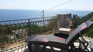 a chair sitting on a balcony overlooking the ocean at Apartments Vila Vino in Sveta Nedelja