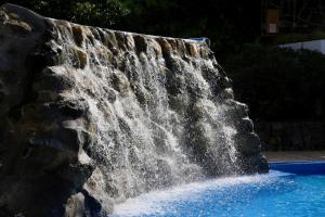 a waterfall in a pool with blue water at Hotel Puerto Palace in Puerto de la Cruz