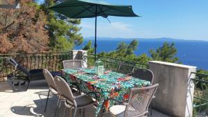 a table and chairs with an umbrella on a balcony at Apartments Vila Vino in Sveta Nedelja