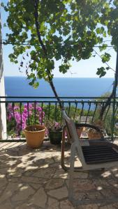 a chair sitting on a patio overlooking the ocean at Apartments Vila Vino in Sveta Nedelja