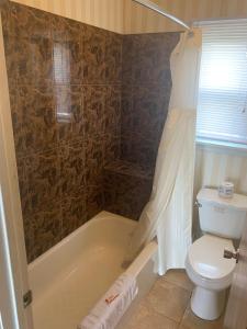 Mt. Vernon Motel في مانهايم: حمام مع حوض استحمام ومرحاض ودش