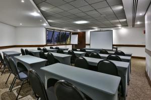 una sala conferenze con tavoli, sedie e schermo di Transamerica Paradise Garden a San Paolo