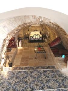 Zimmer mit Blick auf ein Bett und Fliesenboden in der Unterkunft בבית של סבתא וסבא in Safed