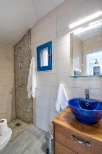 une salle de bain avec un lavabo bleu et un miroir dans l'établissement Villa Akrochori, à Koskinou