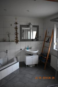 a bathroom with a tub and a sink and a bath tub at Ferienhaus Harzvorland in Ballenstedt