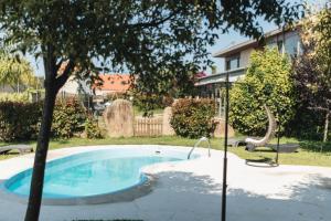 a swimming pool with a slide next to a tree at Peregrina Hotel in Sanxenxo