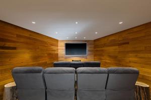 a living room with a couch and a flat screen tv at Calfuco Wine Hotel & Spa in Villa La Angostura +112 photos