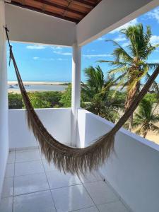 a hammock on a balcony with a view of the beach at CasaMar Guriú in Guriú