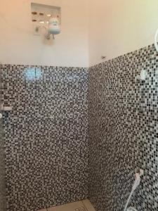 a bathroom with a black and white tiled wall at CasaMar Guriú in Guriú