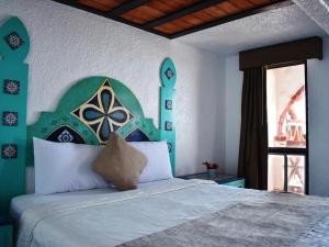 a bedroom with a bed with a large headboard and a window at Castillos Del Mar in Rosarito