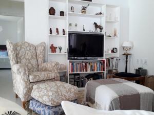 a living room with a chair and a television at CASA DE CAMPO NA CIDADE DA SAÚDE in Serra Negra
