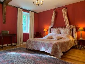 a bedroom with a large bed with red walls at B&B La tour blanche in Forest-Montiers +54 photos