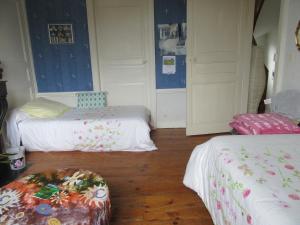 a room with two beds and a ottoman in it at Chez Marie in Pontivy