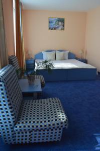 a bedroom with a bed and a couch and a chair at Hotel Shterev Sopot in Sopot