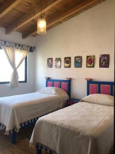 een slaapkamer met 2 bedden en een raam bij CASA FRIDA, Casa p/6 pax Centro Tequisquiapan in Tequisquiapan