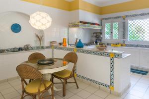 a kitchen with a table and chairs and a counter at Villa Phoenicia in Hammamet