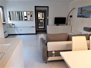 ein Wohnzimmer mit einem Sofa und einem TV in der Unterkunft Apartmen Relax 200 m t Beach in Rovinj