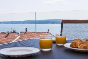 einen Tisch mit zwei Gläsern Orangensaft und Brot in der Unterkunft Abalone Apartments in Dramalj