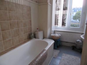 a white bath tub in a bathroom with a window at Chez Marie in Pontivy