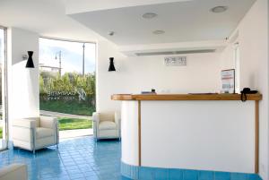 a lobby with a bar with chairs and a window at Ganimede Hotel in Sperlonga