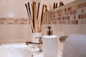 a soap dispenser sitting on top of a sink at Giulia's house apartments in SantʼAntonio Abate