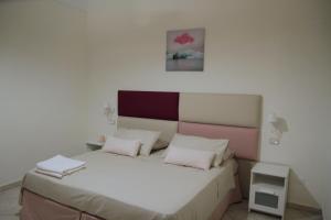 a bedroom with a white bed with pink and white pillows at Giulia's house apartments in SantʼAntonio Abate