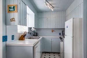 a kitchen with white cabinets and a white refrigerator at Kiwi's Cottage in Gleneden Beach