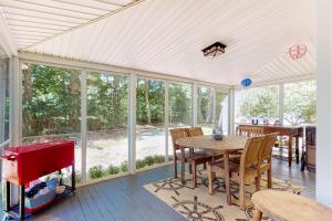 a screened in porch with a table and chairs at Wendell K. Backus House in Cotuit